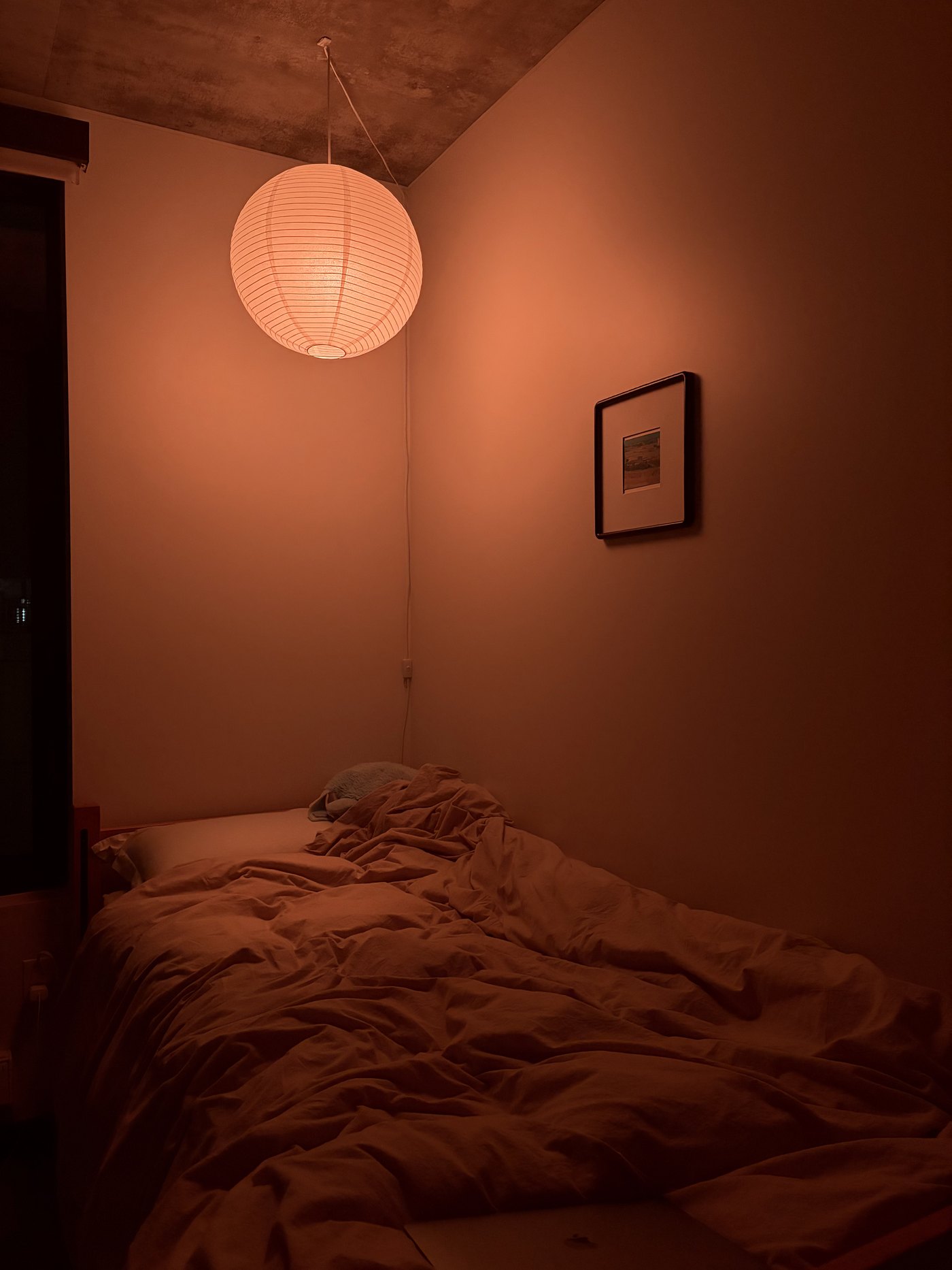 A paper lantern glowing over a bed